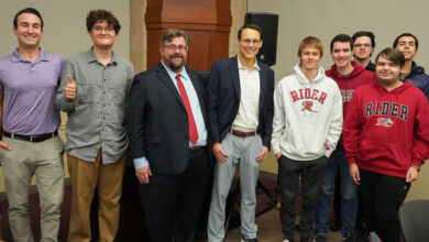 Micah Rasmussen and Steve Kornacki stand with students at a Rebovich event.