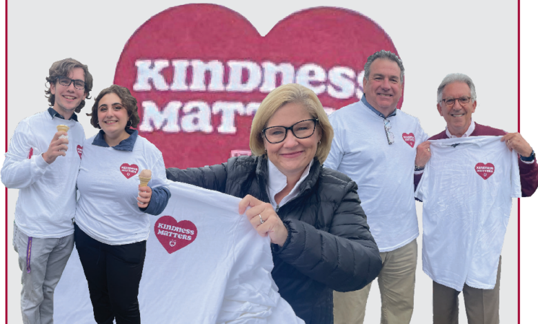 Rider members hold up t-shirts that read "Kindness Matters"