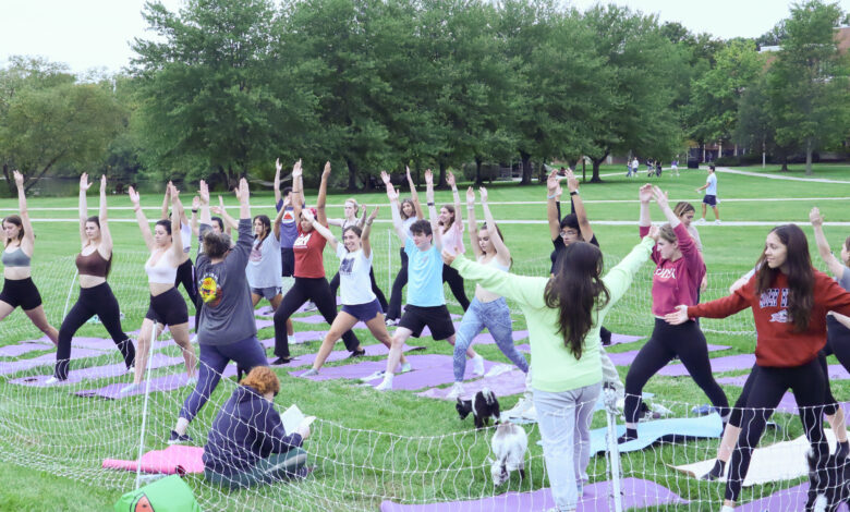 Students pose during a their yoga session surrounded by goats.