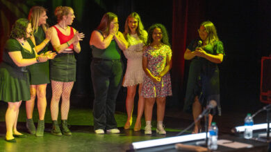 Belcher stands on stage among other contestants.