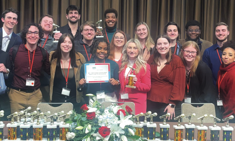 The staff of 107.7 The Bronc stands together for a picture after winning Best College/University Station under 10,000 students at the Intercollegiate Broadcasting Systems ceremony.