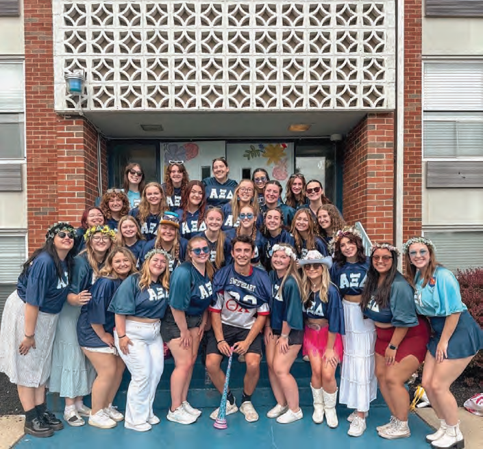 Charles Mule is the sweetheart for Alpha Xi Delta sorority and smiles outside of their house with his sisters.