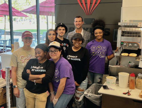 CEO of Saxbys Nick Bayer (back center) stops by to visit the staff of Rider’s Saxbys.
