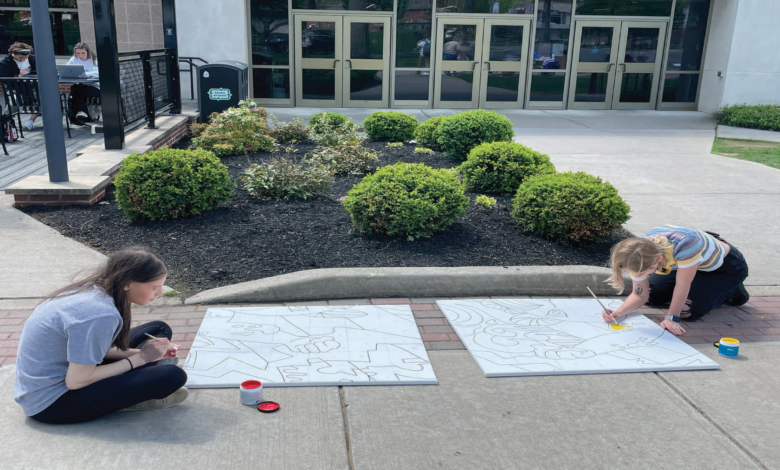 Junior Arts & Entertainment Industries Management majors, junior Rachel Seigerman and senior Sarah Snyder paint outside of the Student Recreation Center (SRC).