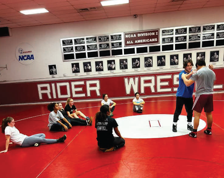 Members of the women’s wrestling club watch a demonstration.