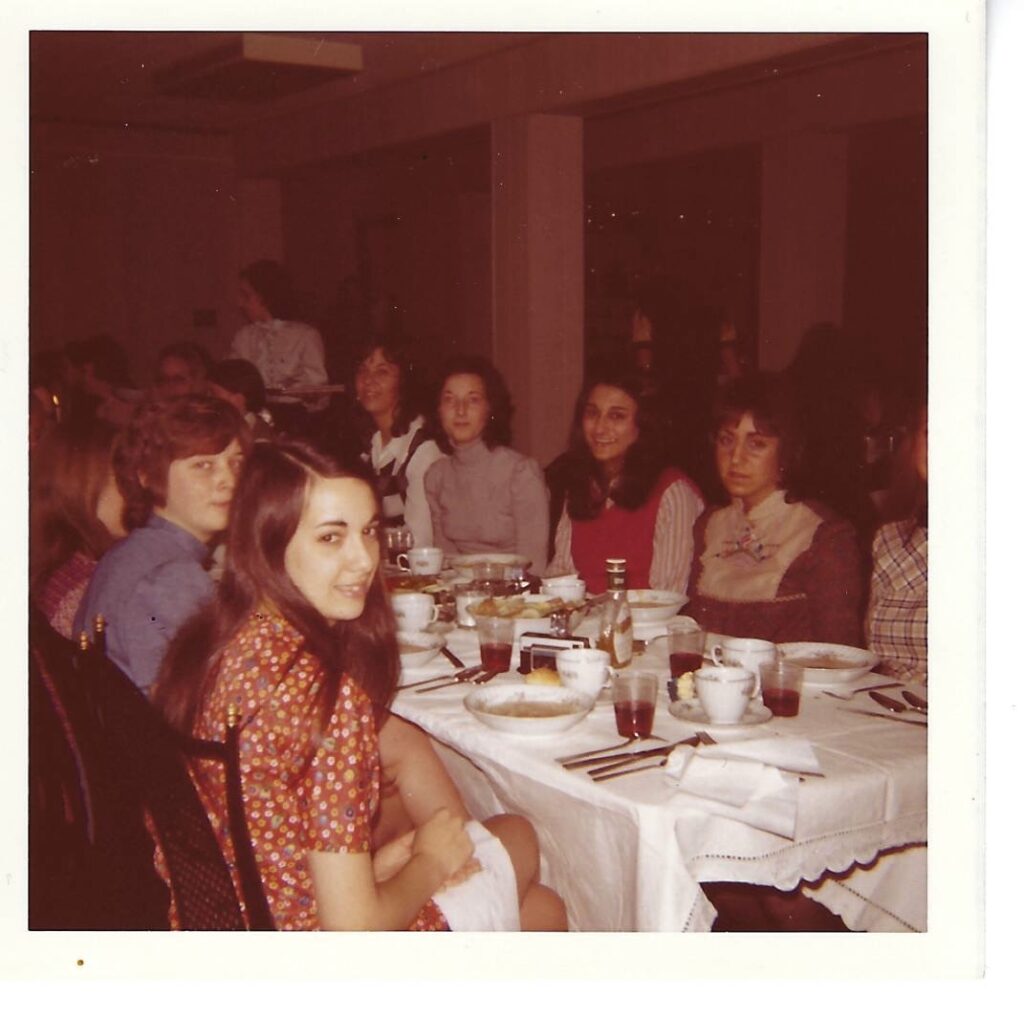oan Mazzotti in the red vest at the Alpha Xi Delta House for 1972 senior dinner.