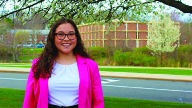 Christina Natoli, SGA presidential candidate, stands in front a tree wearing a pink blazer.