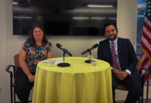 Olivia Newman sits next to Amol Sinha at a table to discuss constitutional rights.