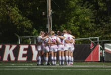 The Broncs huddle up on Ben Cohen Field. Photo by Destiny Pagan