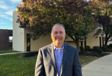 Joe McDougall stands in front of the admissions office.