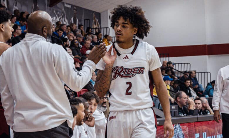 Sophomore guard Ruben Rodriguez fist bumps a coach as he heads to the bench. Photo by Josiah Thomas