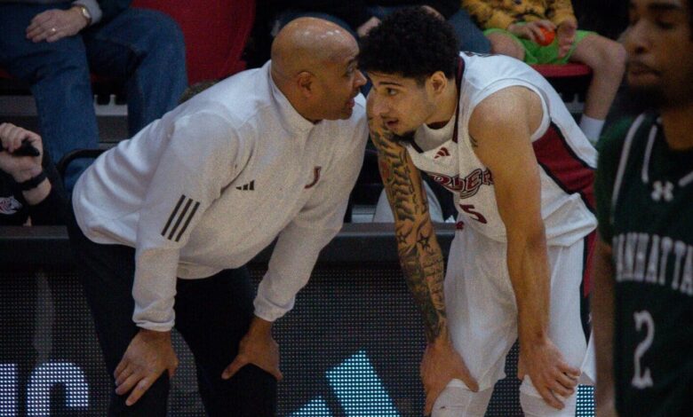 Head Coach Kevin Baggett crouches down and talks with senior guard Jay Alvarez. Photo by Destiny Pagan/The Rider News