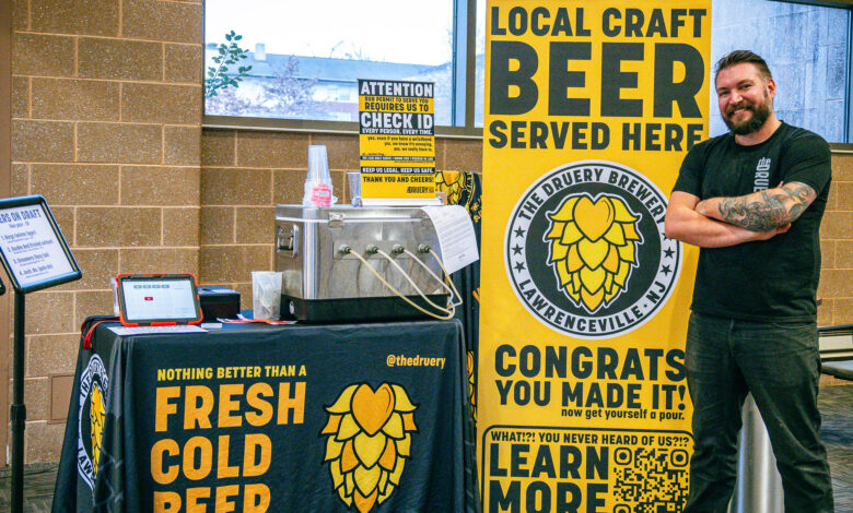 Owner of Druery Brewery, Drew Noel, poses in front of the brewery's sign at the Bronc Fan Zone. Photo by Josiah Thomas