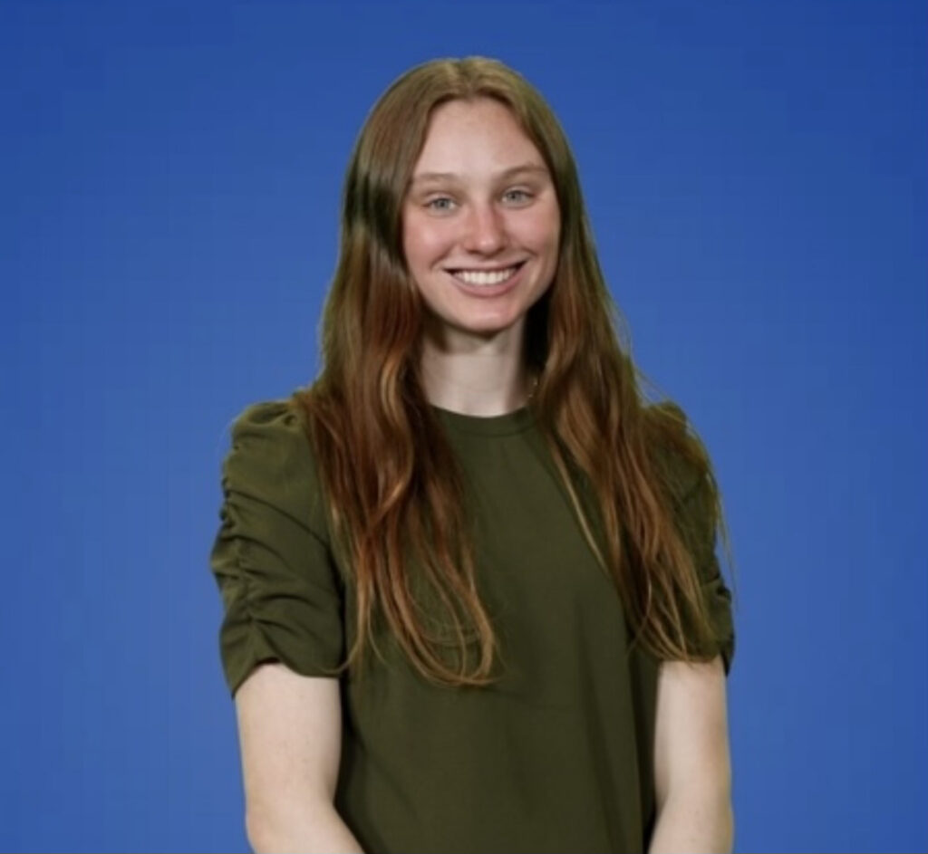  Nicole Filipowicz smiles in front of a blue background.