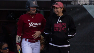 Junior outfielder Fallyn Stoeckel (right) waits on-deck with Head Coach Davon Ortega (right). Photo by Destiny Pagan